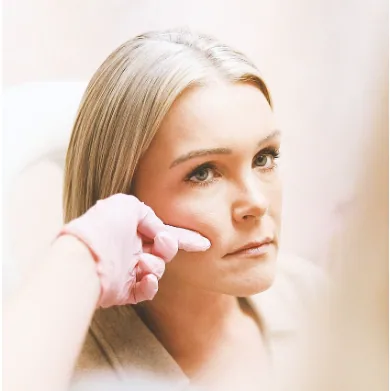 A clinician assessing facial volume before treatment
