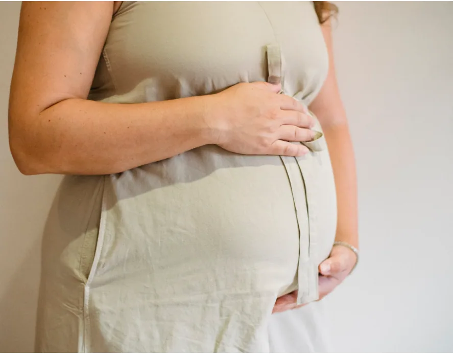 A woman resting her hands on her abdomen